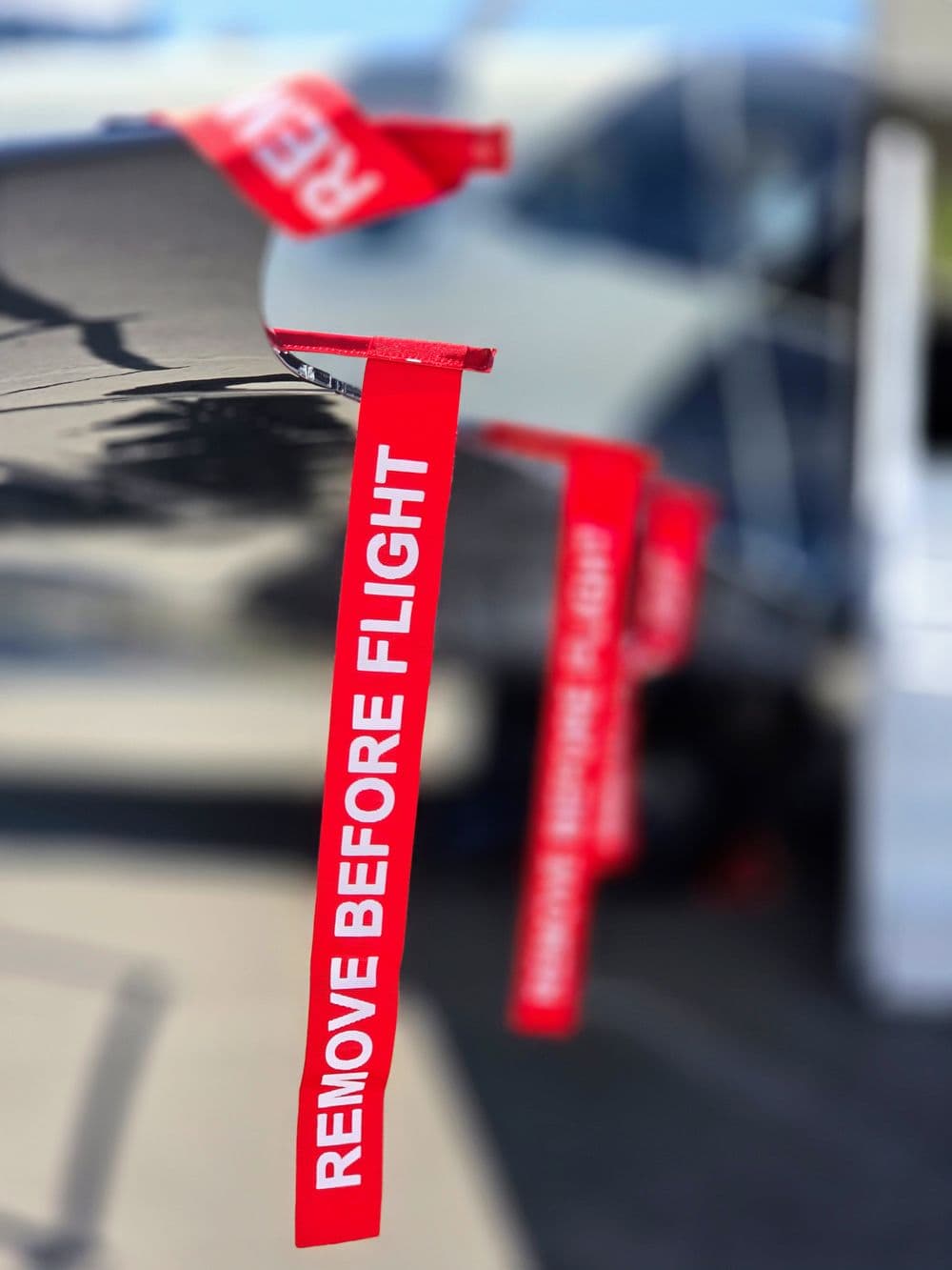 Red Remove Before Flight streamers hanging from a parked aircraft
