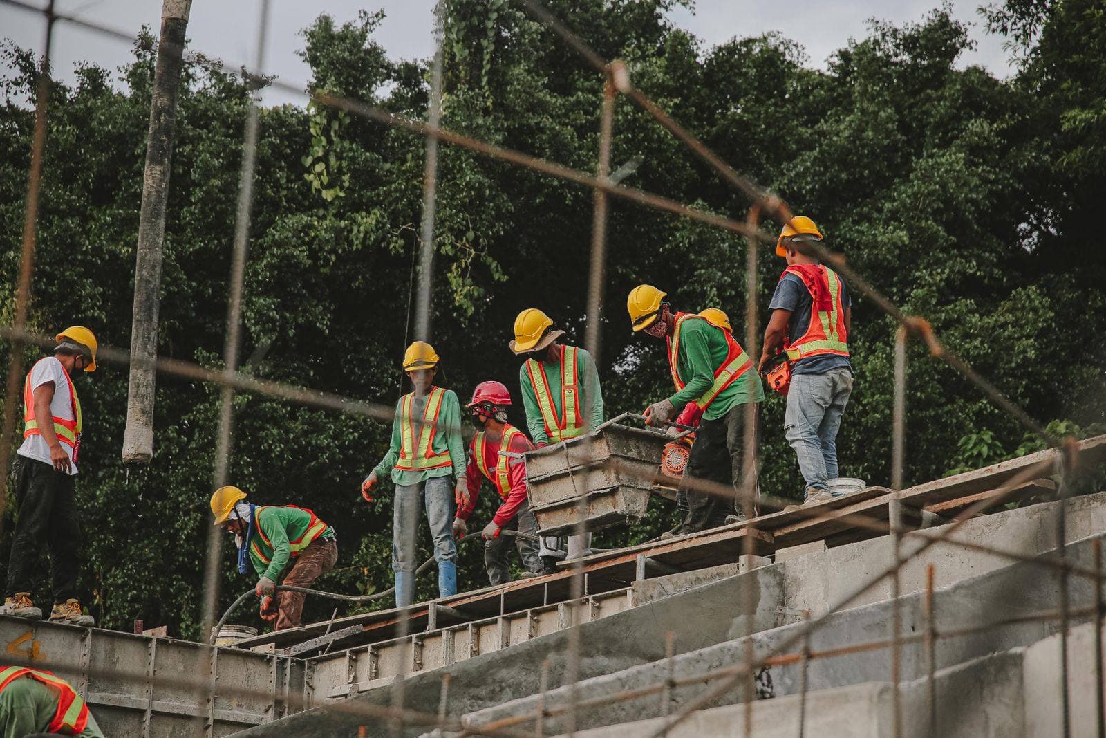 A crew in hard hats and hi-vis vests working together on a concrete structure