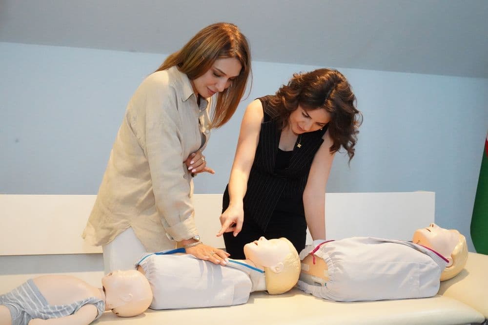 Two women practicing on CPR training manikins during a safety course