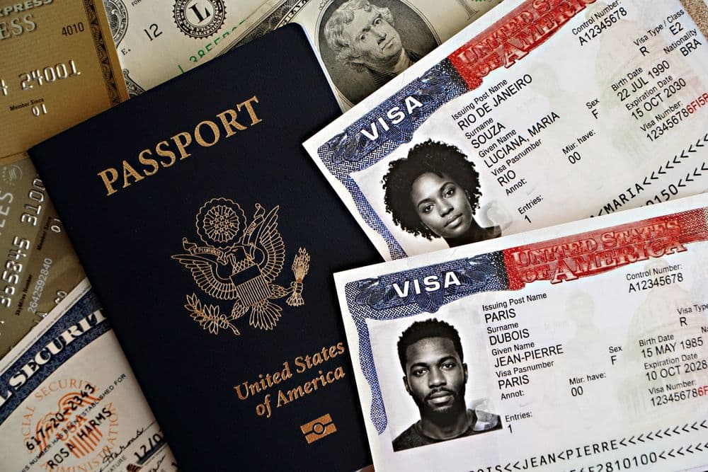 A US passport lying on sample visa documents and banknotes