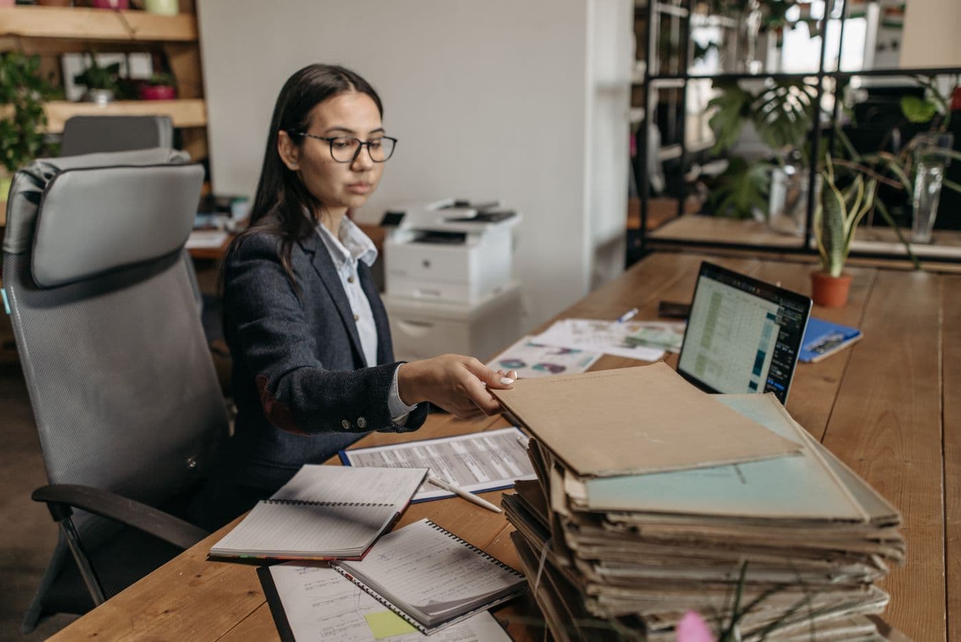 A staffing coordinator at a desk stacked with paper files